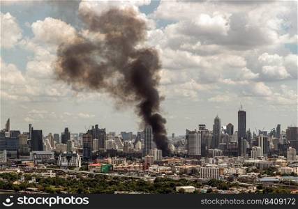 Bangkok, Thailand - 21 Jun, 2022   Plume of black smoke clouds from burnt building on fire at community area in the bangkok city. Fire disaster accident, No focus, specifically.