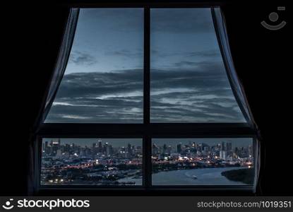 Bangkok, Thailand - 27 Aug, 2019 : The beautiful view of Bangkok, the beautiful skyscrapers along the Chao Phraya River in the evening seen through a bedroom window.