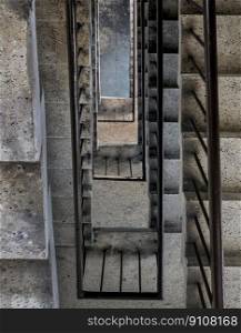 Bangkok, Thailand - 27 Feb 2023 - View from above of concrete spiral staircases pattern of square shape are in the old building architecture, Looking down at interior ground floor of old building which are deteriorated over time, Space for text.