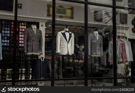 Bangkok, Thailand - Apr 02, 2022   Luxury shop window with Stylish men’s suits on mannequins. Men’s elegant clothes, Shopping concept, Street view form outside, No focus, specifically.