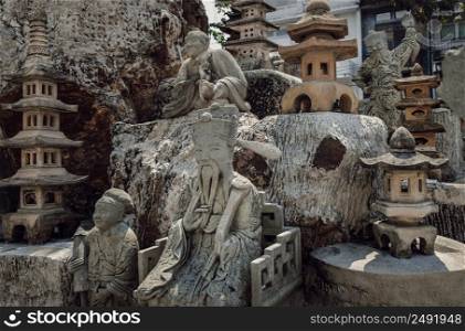 Bangkok, Thailand. Apr - 15, 2022 : Various ancient chinese art stone elaborate sculptures in stone garden or rock garden of The Suthat hepwararam ratchaworamahawihan temple. Thailand, Selective focus.