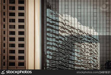 Bangkok, Thailand - Apr 22, 2022 : Sky and buidings reflection on Glass wall of building with repeating structure. Exterior architecture of modern building, View from the outside, Copy space, Selective focus.