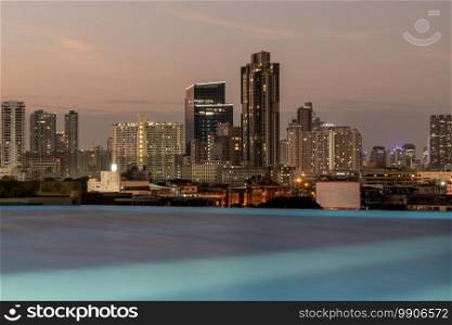 Bangkok, thailand - Dec 30, 2020   Silhouette of Bangkok city skylines with light reflection in swimming pool during sunset. Selective focus.