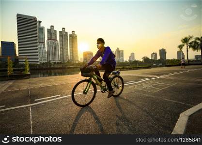 bangkok thailand - february3,2019 : unidentifies man wearing clothes mask for protect dust riding bicycle in heart of bangkok thailand capital,dust pm.2.5 is largest weather problem in thailand capital