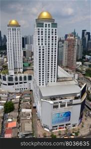 BANGKOK, THAILAND - JUNE 20, 2016: Bangkok city scape. The small houses are surrounded by the commercial buildings