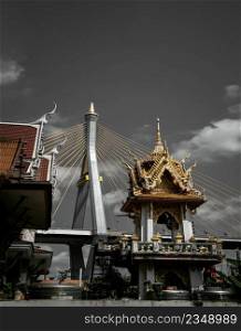 Bangkok, Thailand. Mar - 12, 2022   Beautiful view of Buddhist thai temple with suspension bridge background can coexist perfectly. No focus, specifically.