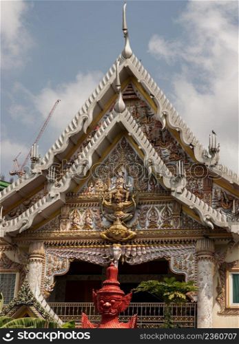 Bangkok, Thailand. Mar - 12, 2022   Stucco figure the red giant standing guardian at the entrance of the ordination hall in Wat khlong phum temple. No focus, specifically.