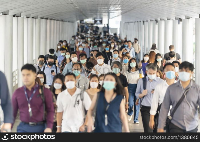 BANGKOK, THAILAND - MAR 2020 : Crowd of unrecognizable business people wearing surgical mask for prevent coronavirus Outbreak in rush hour working day on March 18, 2020 at Bangkok transportation