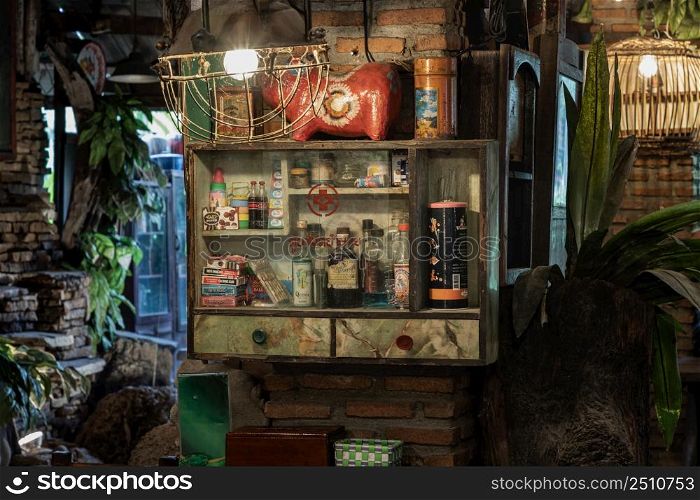 Bangkok, Thailand, May 01, 2022 : Vintage medicine bottles and Antique collectibles sitting on a store shelf in Cabinet for old wooden storage of medicine to Decorate the interior of country-style house. Selective focus.