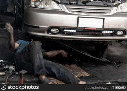 Bangkok,Thailand - Nov 15, 2019 : A mechanic is repairing front suspension of the car at the repair service garage. Selective focus.