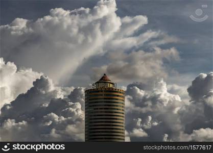 Bangkok, Thailand - Sep 24, 2020 : Angular geometric mirror cladding on a modern building with repeating structure and reflected sky and clouds. No focus, specifically.