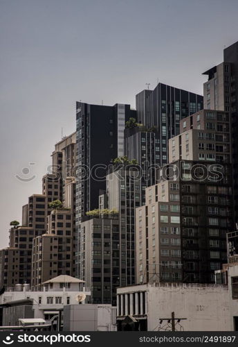 Bangkok,Thailnad - Apr 14, 2022 : Architectural view of Overlapping city skyscrapers. Beautiful of Modern high-rise buildings with repeating structure glass and reflected. Angular geometric of building design, Focus and blur.