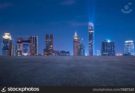 Bangkok urban cityscape skyline night scene with empty asphalt floor on front