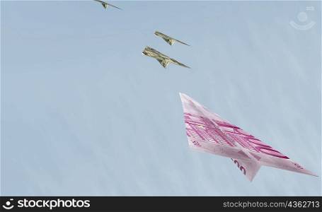 Bank notes in the shape of airplanes flying in the sky