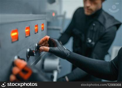 Bank robbery, robbers in black uniform trying to find the code and to open the vault door. Criminal profession, theft concept. Robbers in black uniform trying to find the code