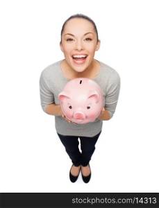 banking and investment concept - laughing woman with piggy bank