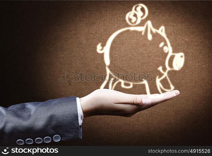 Banking concept. Close up of businessperson hand holding piggy bank
