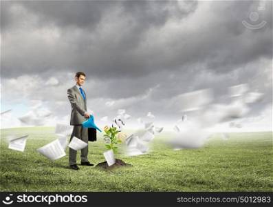 Banking concept. Image of young businessman watering money tree with euro symbols