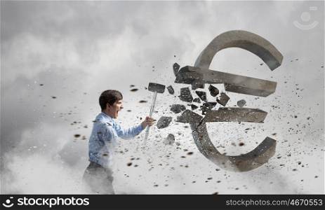 Banking concept. Young businessman crashing with hammer stone euro symbol