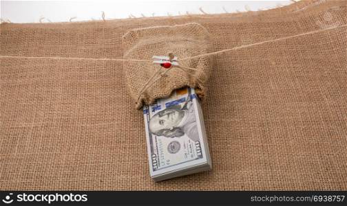 Banknote bundle of US dollarin a sack on a canvas