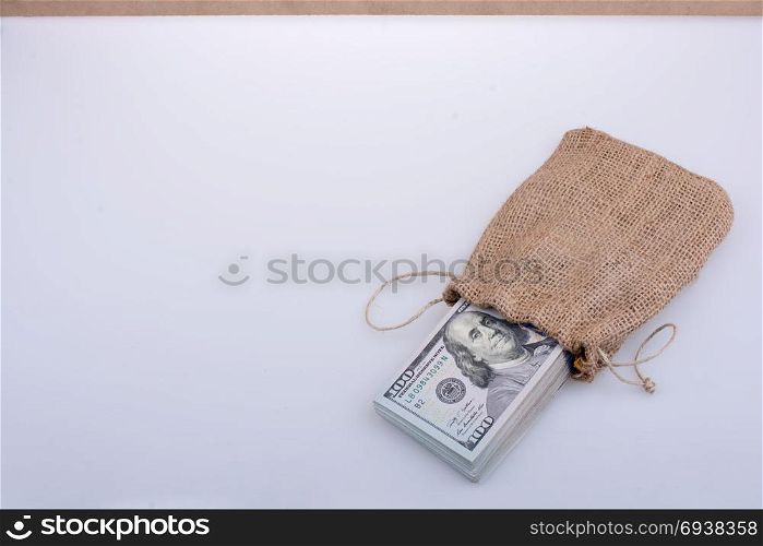 Banknote bundle of US dollarin a sack on a white background