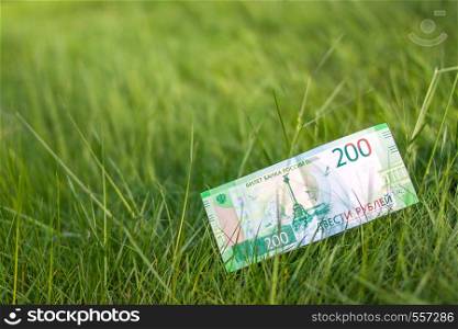 Banknote Two hundred russian rubles. Cash paper green money. with grass background. Space for text. Banknote Two hundred russian rubles.