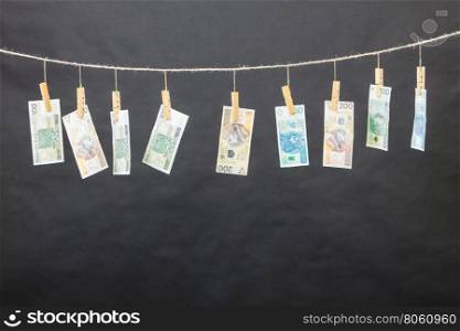 Banknotes on laundry line. Banknotes cash money hang on laundry line on black background.