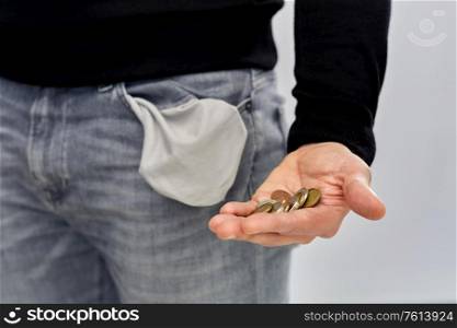 bankruptcy, financial crisis and poverty concept - close up of man showing hand with euro money coins and empty pockets over grey background. close up of man showing coins and empty pockets