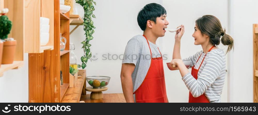 Banner and cover scene of Happy Asian Lover or couple cooking in happiness action in the kitchen room at the modern house, Couple and life style, kitchen and food concept.