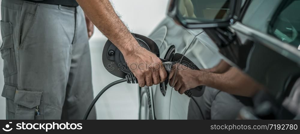 Banner and cover scene ofCloseup hand of technicial charging the car electrict in maintainance service center which is a part of showroom, economic and technology for safe the world concept