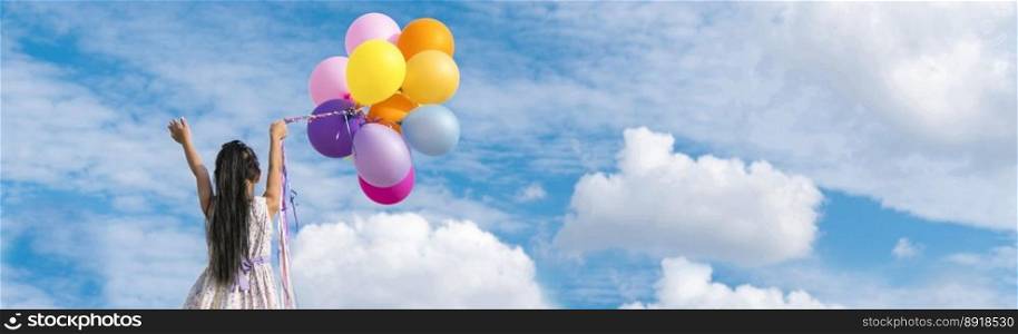 Banner Cheerful cute girl holding balloons running green meadow white cloud and blue sky with happiness. Panorama Hands holding vibrant air balloons happy times summer sunlight outdoor copy space