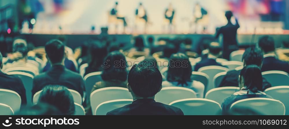 Banner cover page of Rear view of Audience listening Speakers on the stage in the conference hall or seminar meeting, business and education about investment concept