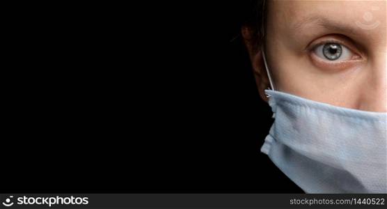 banner of a woman&rsquo;s face in a medical mask on black background, an outbreak of coronavirus infection and protection from it. close- up, Studio portrait on a dark. copy space, look at the camera.. banner of a woman&rsquo;s face in a medical mask on black background, an outbreak of coronavirus infection and protection from it. close- up, Studio portrait on a dark. copy space, look at the camera