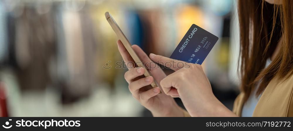 banner of Asian woman using credit card with mobile phone for online shopping in department store over the clothes shop store, technology money wallet and online payment concept, credit card mockup