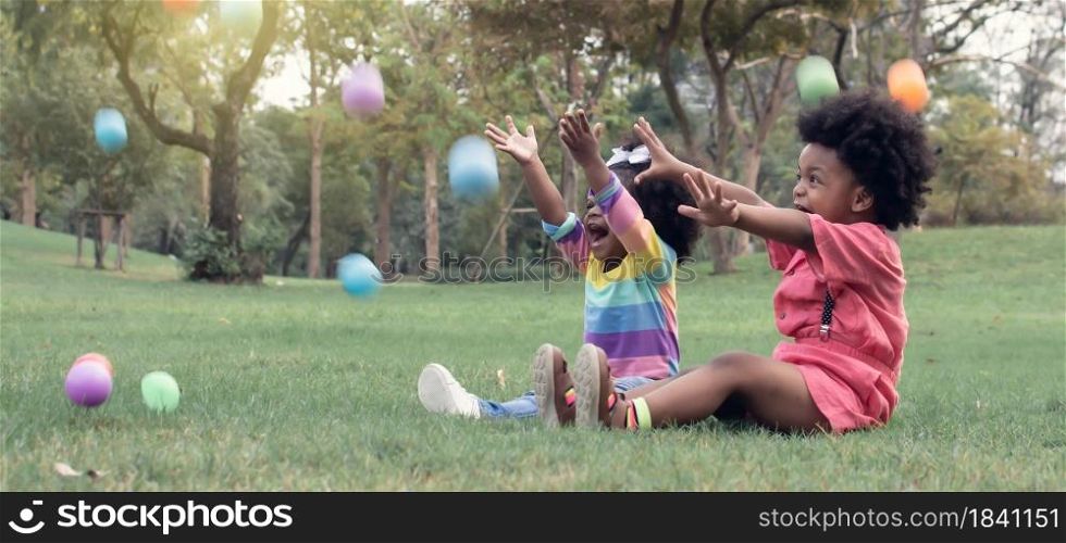 Banner of Little African boy and girl is playing with colorful balls in the park