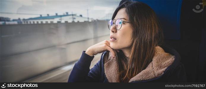 Banner or web page of Asian Young lady passenger Sitting in depressed mood beside the window inside Train which travel between town when travel alone for escape the chaos,traveller and depress concept