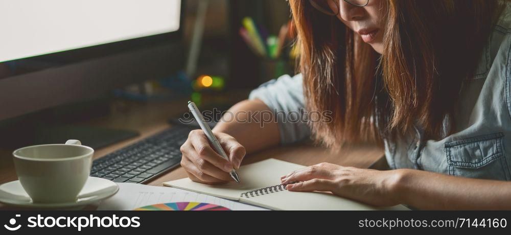 Banner, web page or cover template of Asian Businesswoman sitting and working hard on the table with front of computer desktop in workplace or office at late time, Work hard and too late concept