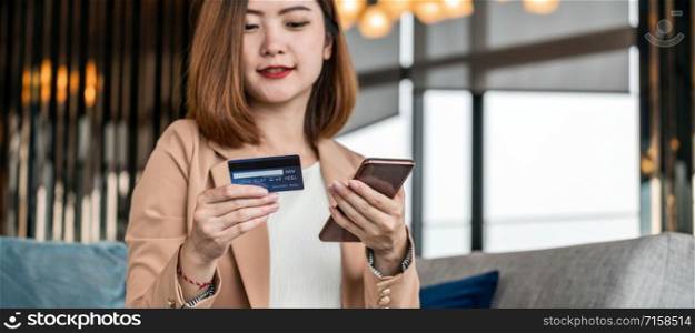 Banner, web page or cover template of Asian woman using credit card with mobile phone, laptop for online shopping in modern lobby, technology money wallet and online payment concept,credit card mockup