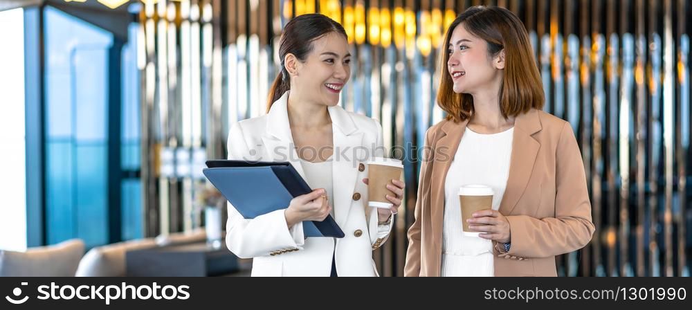 Banner, web page or cover template of Two asian businesswomen talking during coffee break in modern office or coworking space, coffee break,relaxing and talking,business and people partnership concept