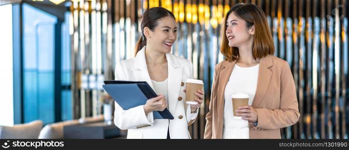 Banner, web page or cover template of Two asian businesswomen talking during coffee break in modern office or coworking space, coffee break,relaxing and talking,business and people partnership concept