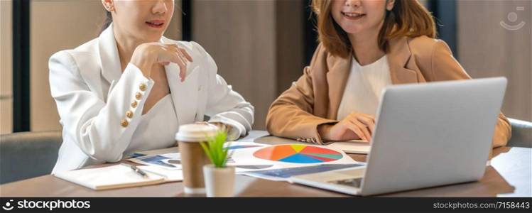 Banner, web page or cover template of Two asian businesswomen working with the partner business via technology laptop in modern meeting room, office or working space, partner and colleague concept