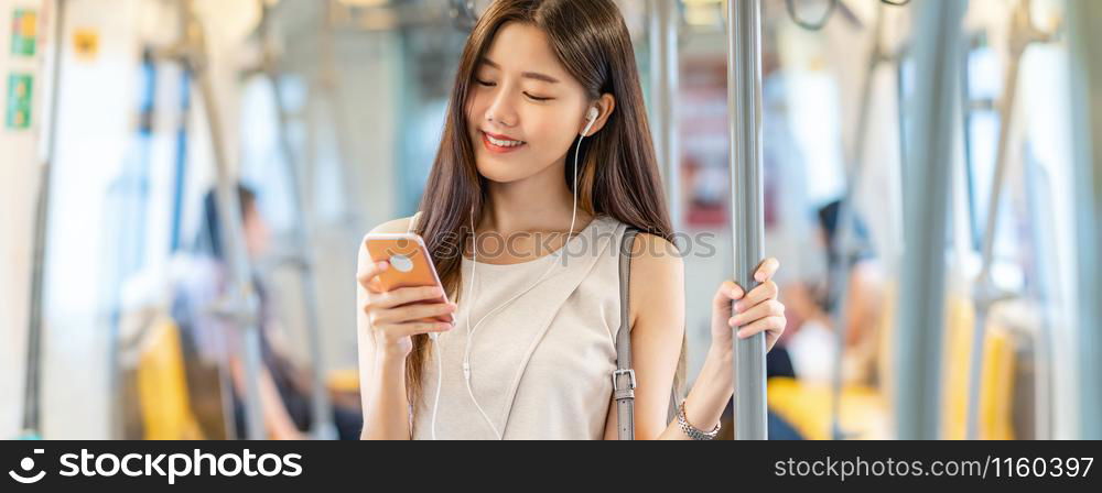 Banner, web page or cover template of Young Asian woman passenger using and listening music via smart mobile phone in subway train station, japanese,chinese,Korean lifestyle, leisure and daily life,