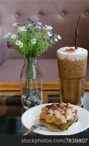 Banoffee pie on white dish with silver fork and ice coffee. Banoffee pie
