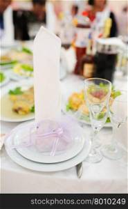 Banquet wedding invitation on table setting on evening reception awaiting guests. Banquet wedding invitation on table setting on evening reception