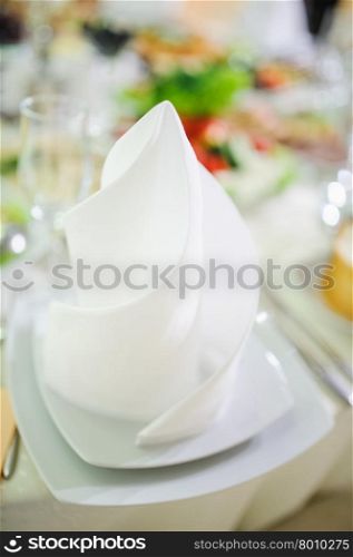 Banquet wedding table setting on evening reception awaiting guests. Banquet wedding plate on table setting on evening reception
