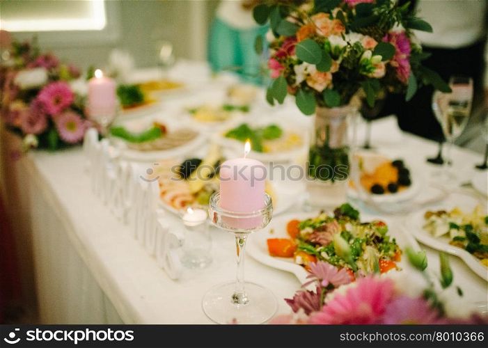Banquet wedding table setting on evening reception awaiting guests with candle. Banquet wedding table setting on evening reception