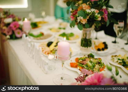 Banquet wedding table setting on evening reception awaiting guests with candle. Banquet wedding table setting on evening reception