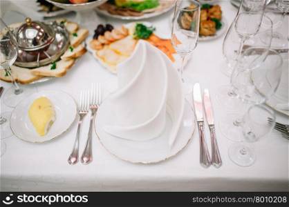 Banquet wedding table setting with plate, spoon, fork and knife