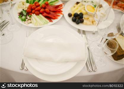 Banquet wedding table setting with plate, spoon, fork and knife