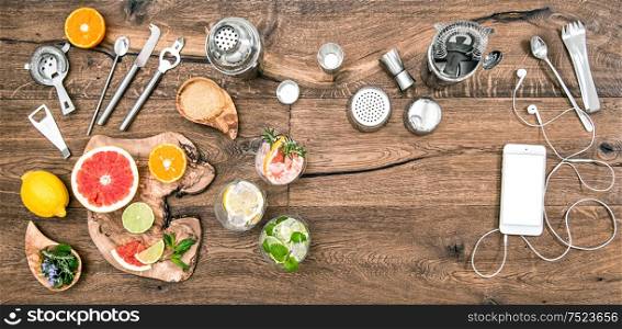 Bar counter with drinks, tools, accessories and electronic devices. Flat lay background